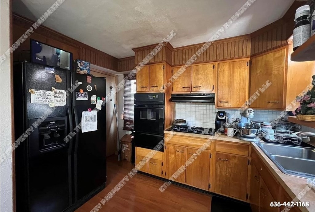a kitchen with black appliances and wooden cabinets