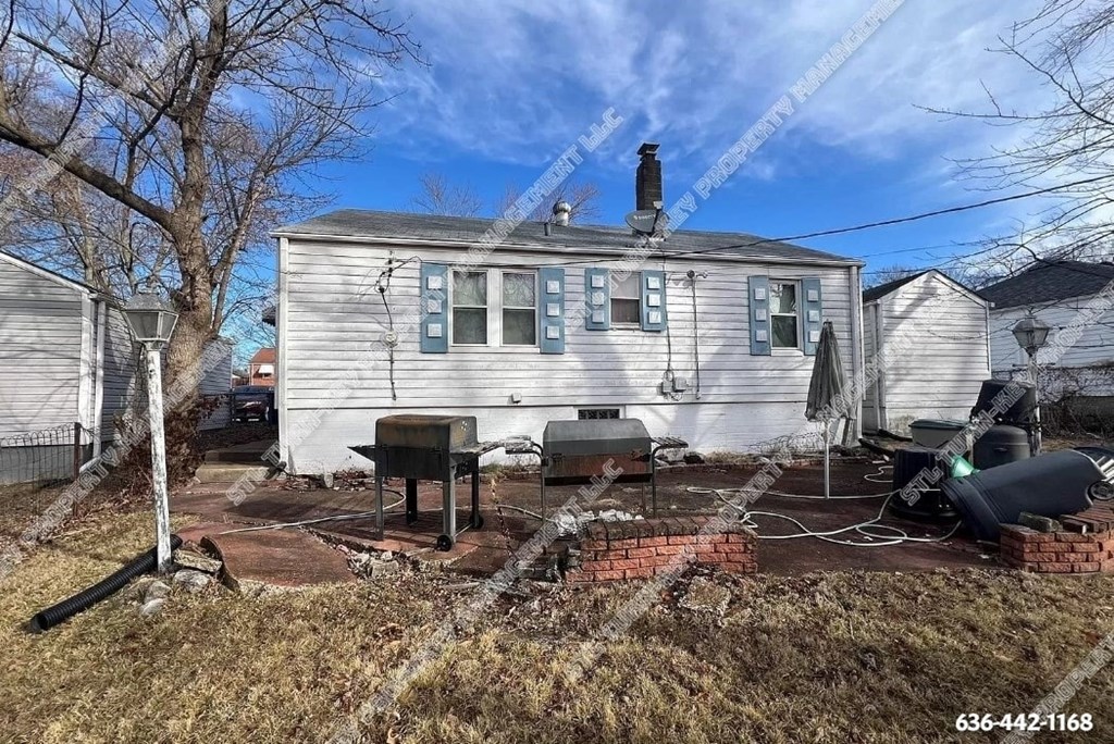 a white house with a backyard with a yard and a grill