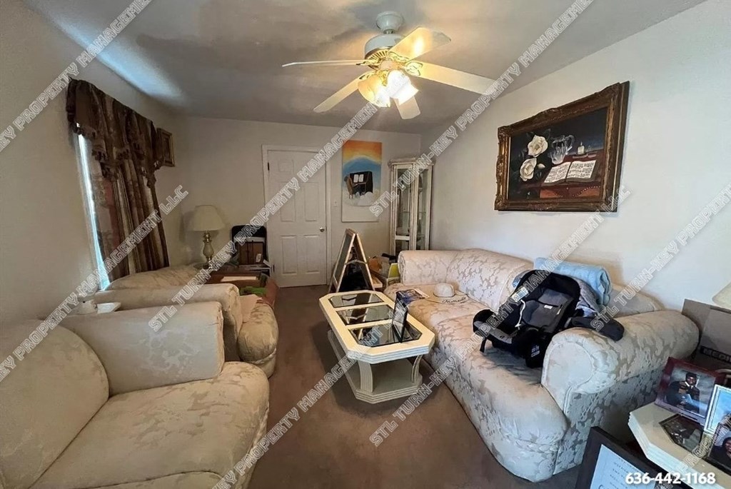 a living room with furniture and a ceiling fan