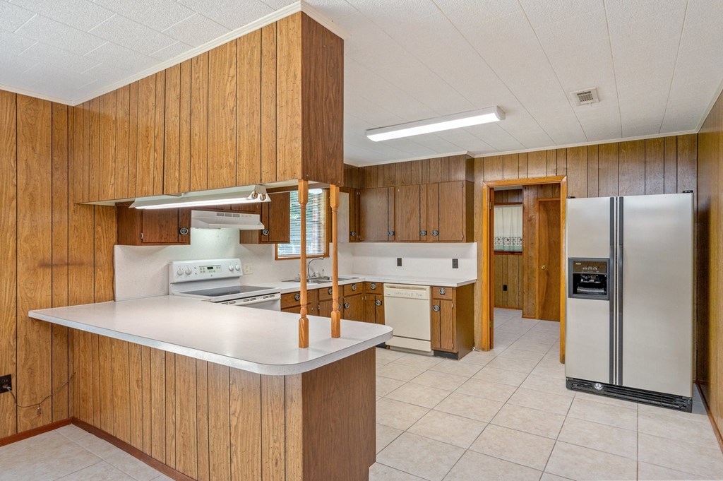 a kitchen with a white counter top and a refrigerator