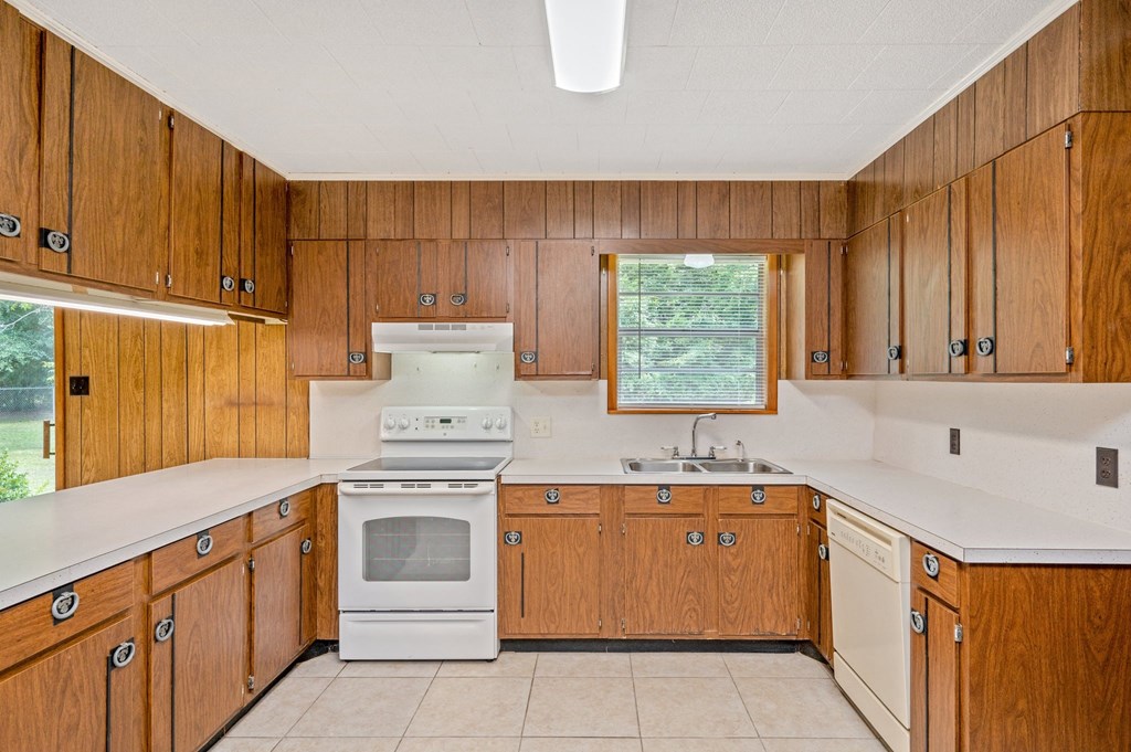 a kitchen with white appliances and wooden cabinets