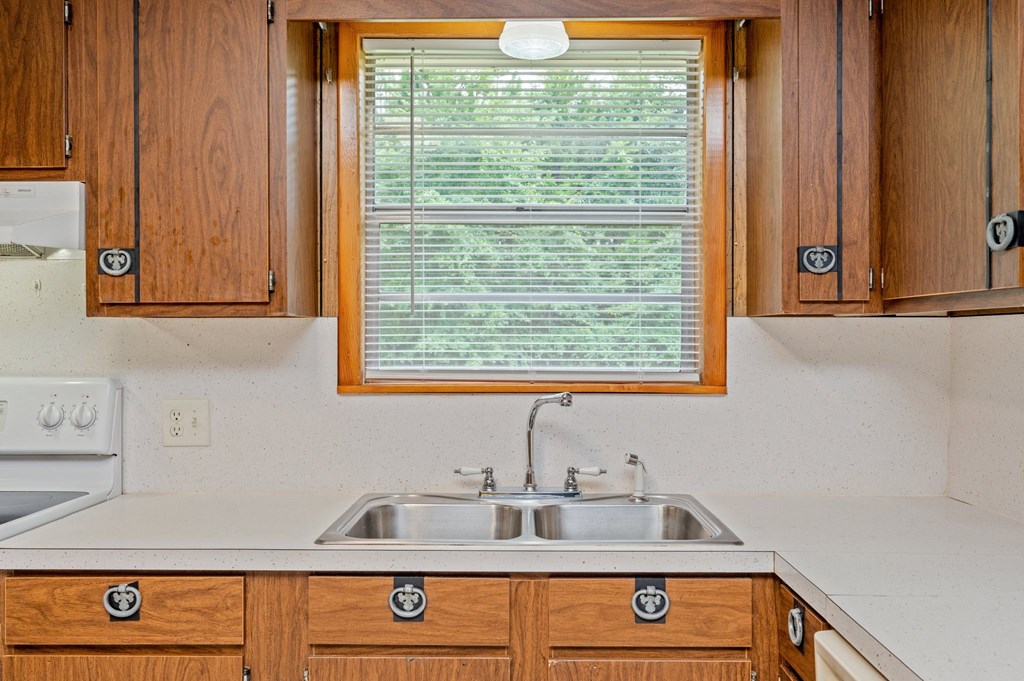 a kitchen with wooden cabinets and a sink and a window