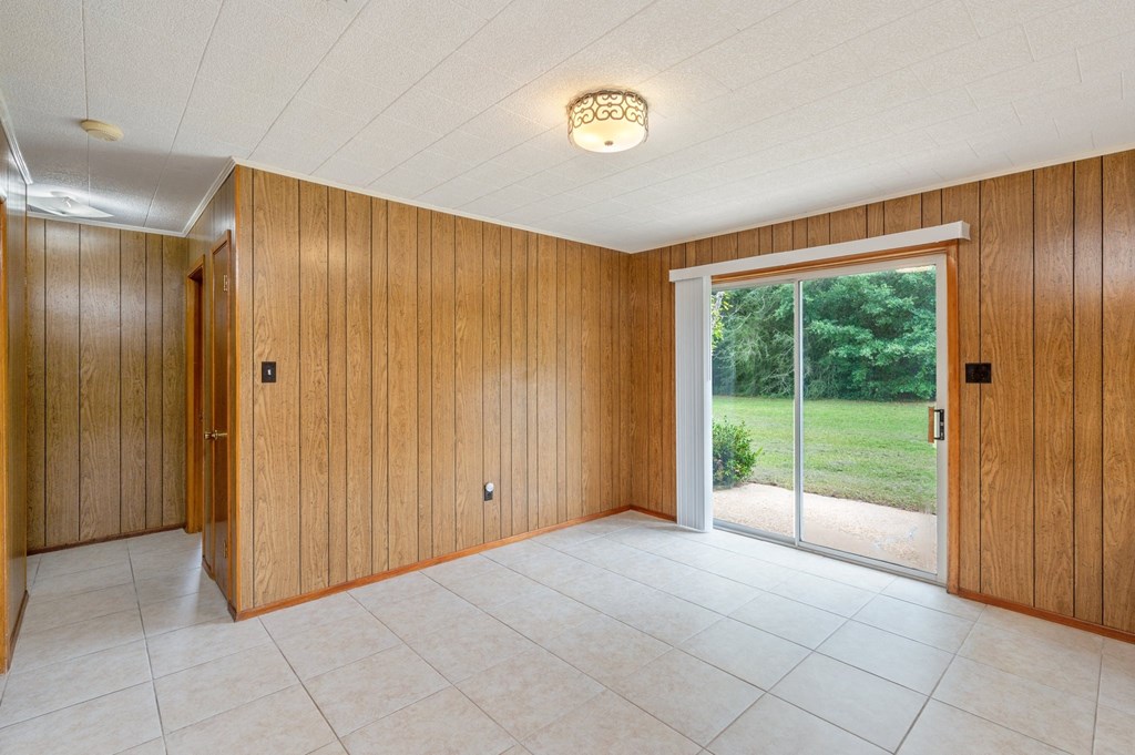 a living room with wood paneling and a sliding glass door