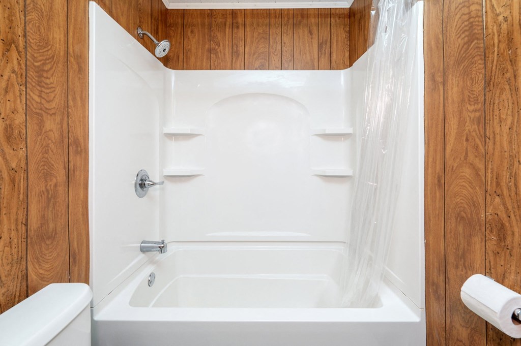 a white bathroom with a shower and a toilet