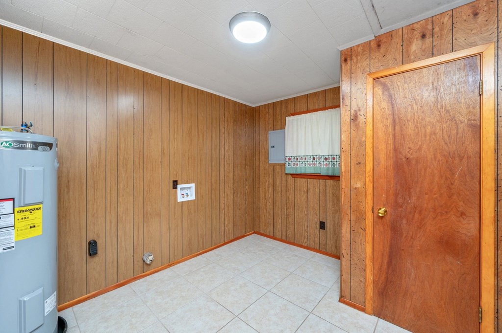 a utility room with a refrigerator and a wooden door
