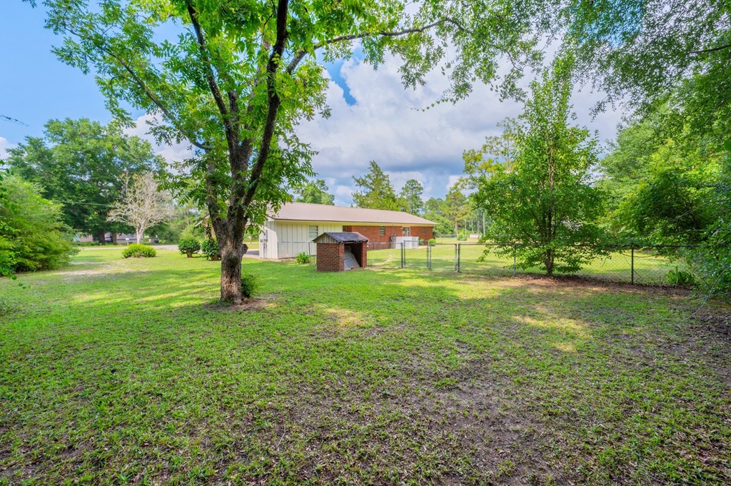 a house with a yard and trees in front of it
