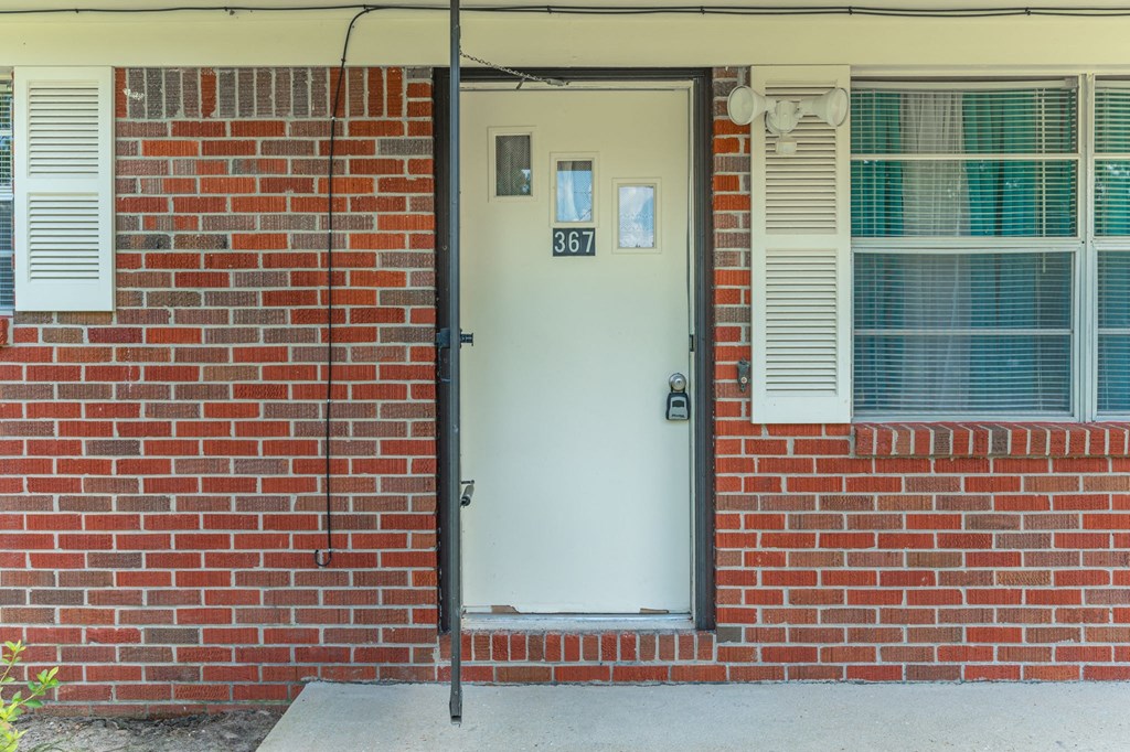 the front door of a brick building with a white door