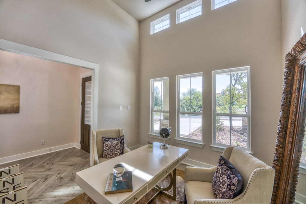 a living room with a table and chairs and a mirror