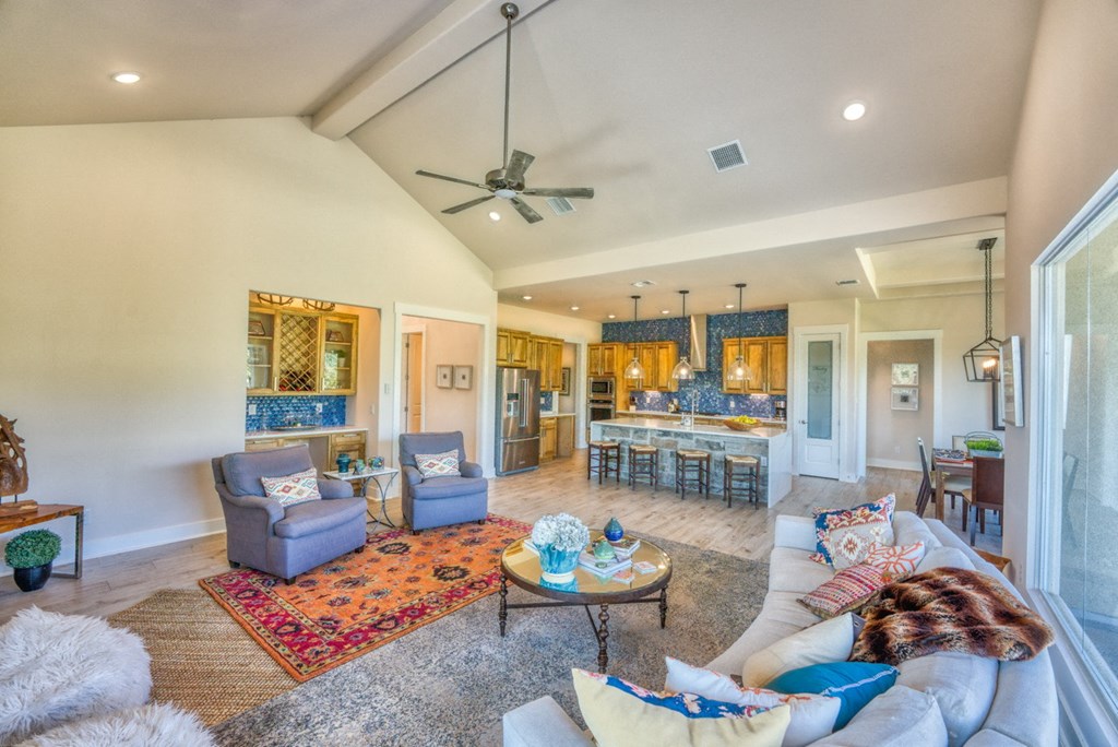 a living room with couches and chairs and a kitchen
