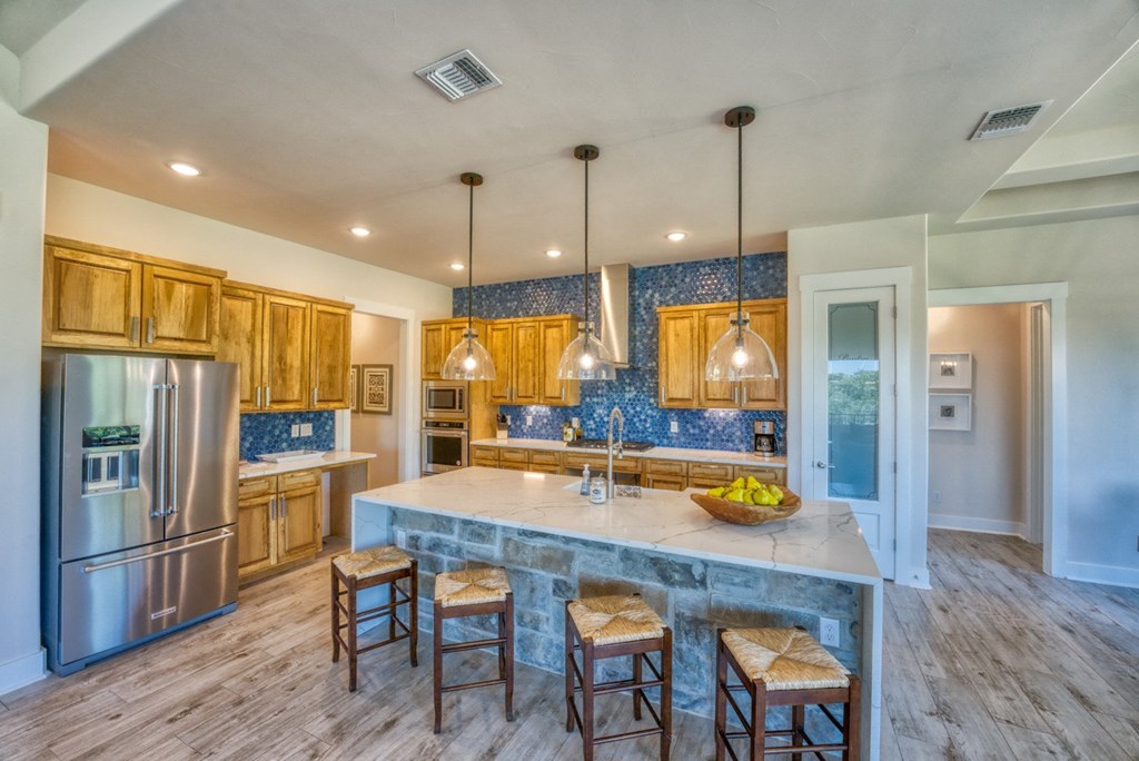 a kitchen with a large center island with three stools