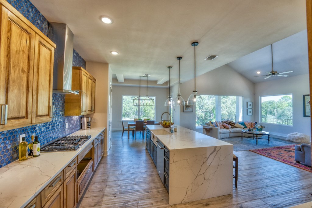 a large kitchen with marble counter tops and wooden cabinets