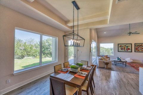 a dining room with a table and chairs and a large window