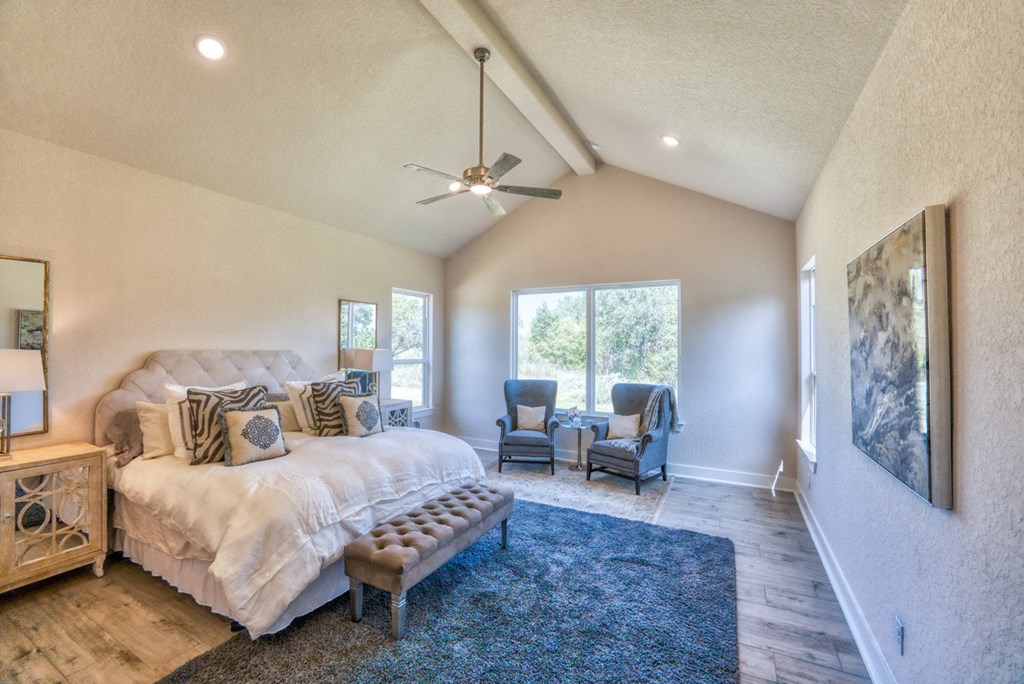 a bedroom with a large bed and a ceiling fan