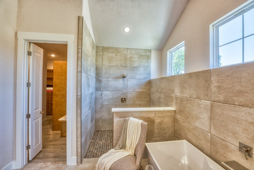 a bathroom with a tub and a sink and a window