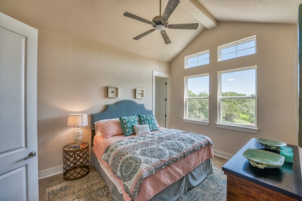 a bedroom with a large bed and a ceiling fan