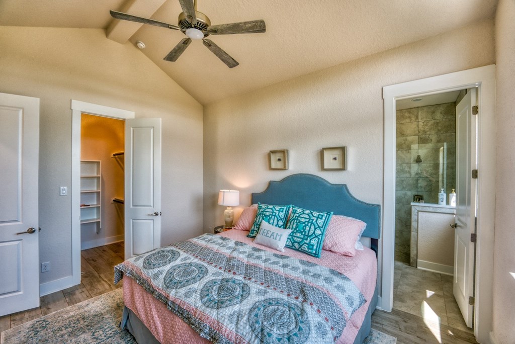 a bedroom with a bed and a ceiling fan