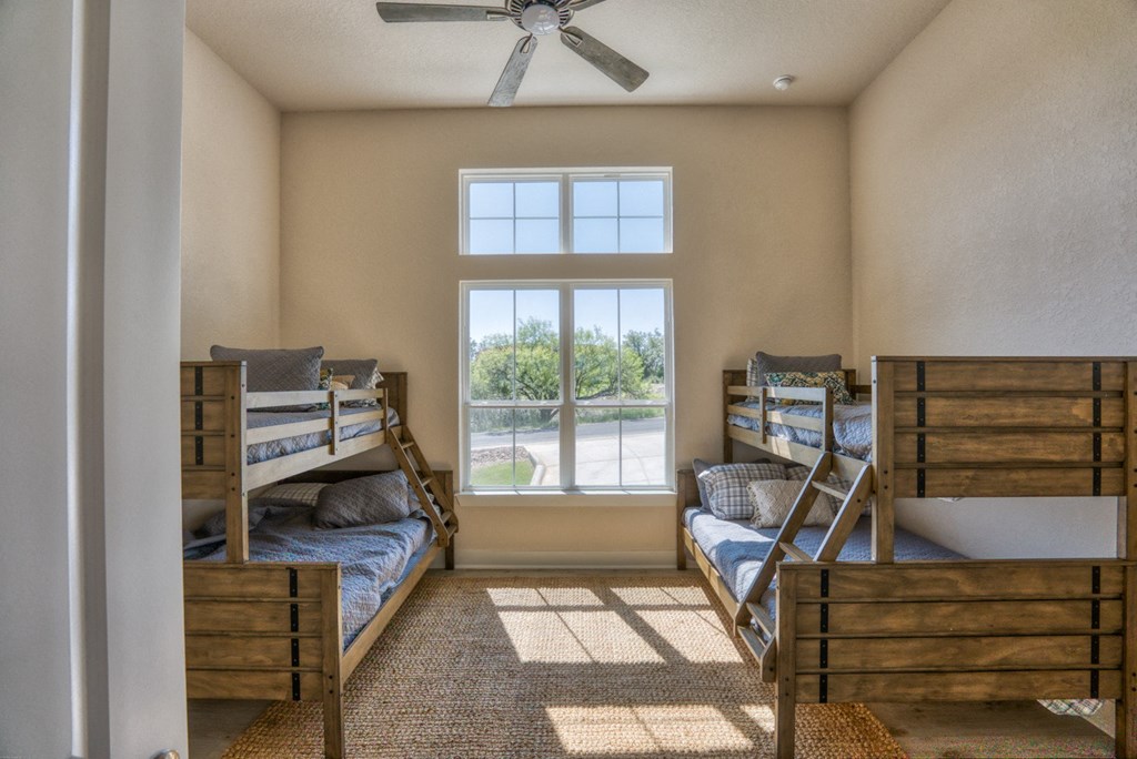 two bunk beds in a room with a ceiling fan