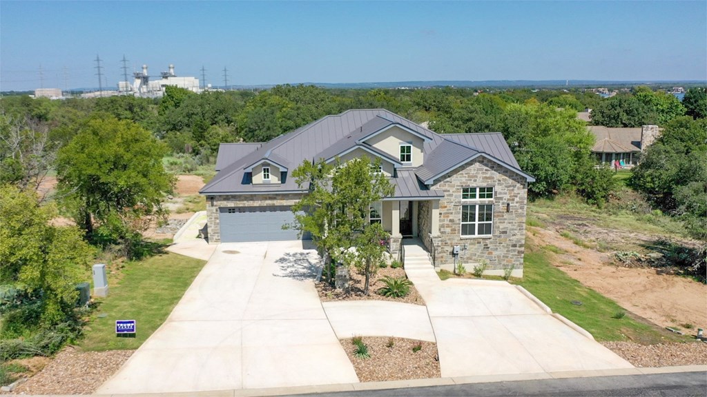 an aerial view of a house with a gray roof and a driveway