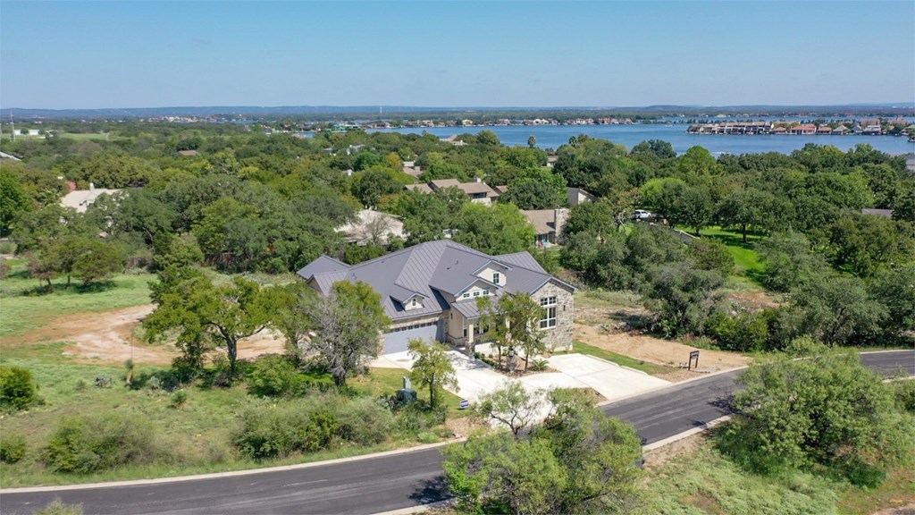 an aerial view of a house with a lake in the background