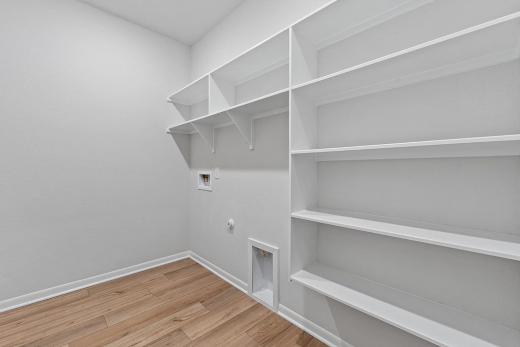 a room with white shelves and a wood floor