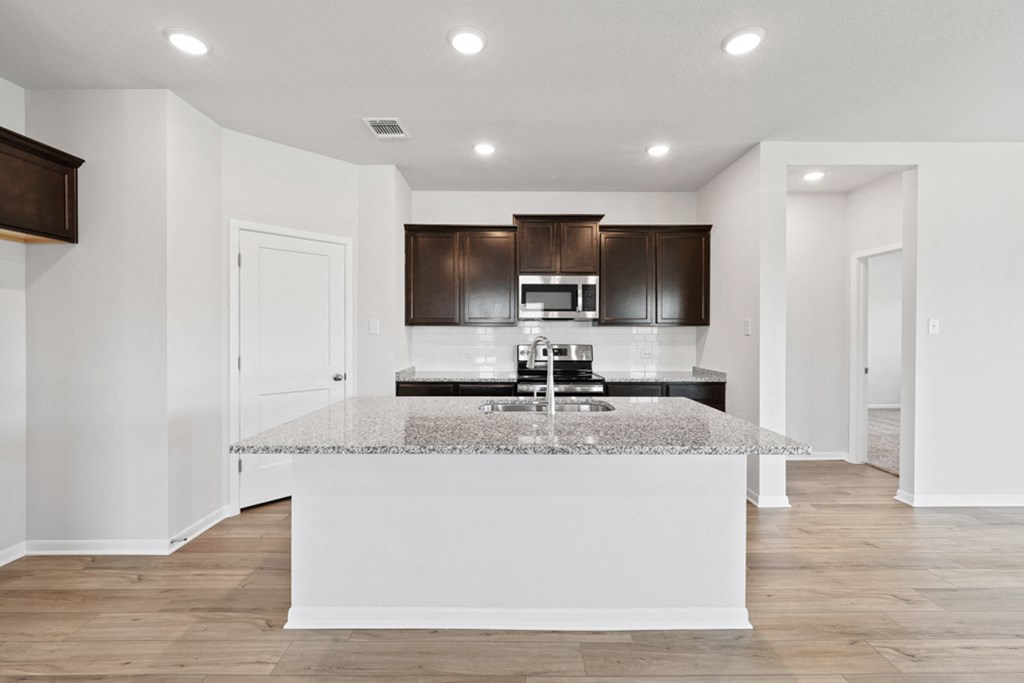 a kitchen with white walls and a marble counter top
