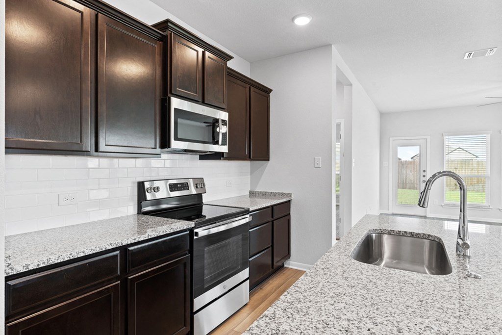 the kitchen of a new home with granite counter tops and black and white appliances