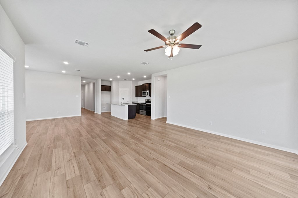 a living room with hardwood floors and a ceiling fan