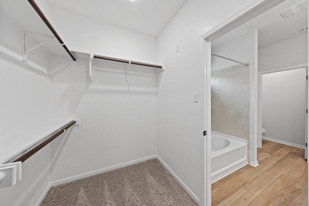 a renovated bathroom with white walls and wood flooring and a walk in shower