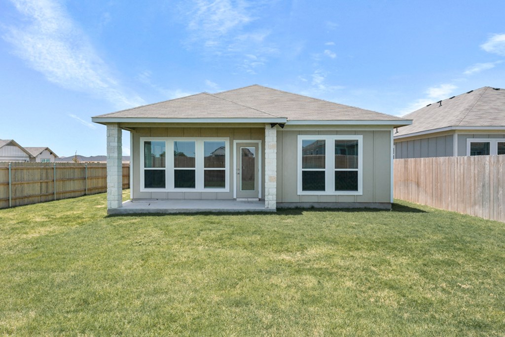 a small house with a yard and a fence