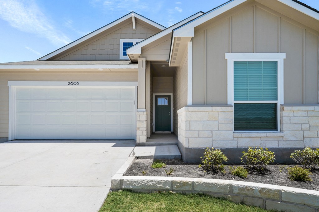 a house with a garage door in front of it