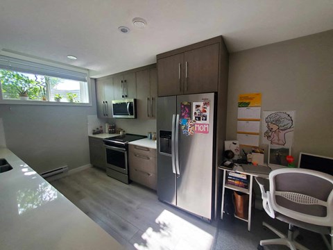 a kitchen with a refrigerator and a table and chairs