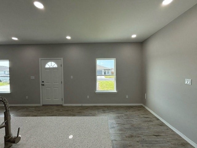 a empty gray room with a door and a window