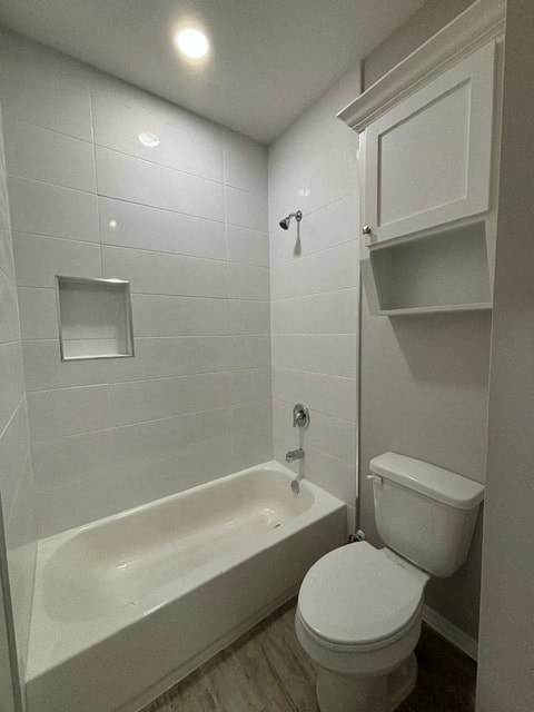 a white bathroom with a toilet and a bath tub
