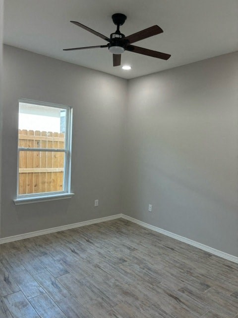 an empty room with a ceiling fan and a window