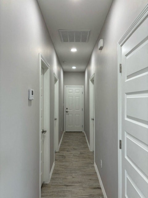 a long hallway with white doors and a wood floor