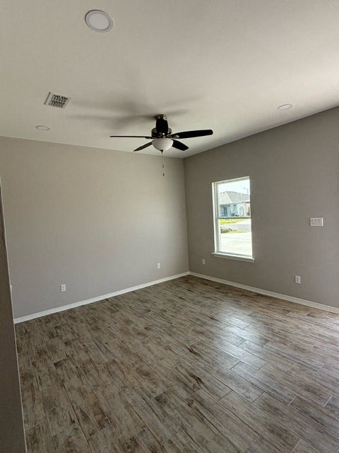 an empty living room with a ceiling fan and a window