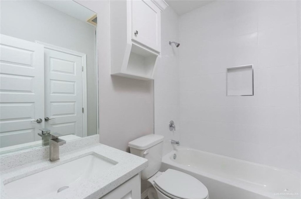 a white bathroom with a sink toilet and shower
