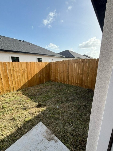 a backyard with a wooden fence in front of a house