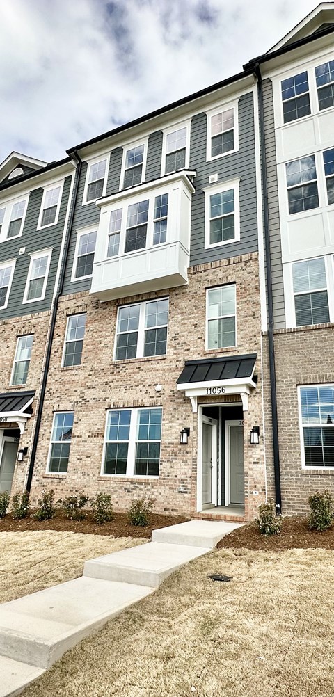 front view of a brick apartment building with stairs