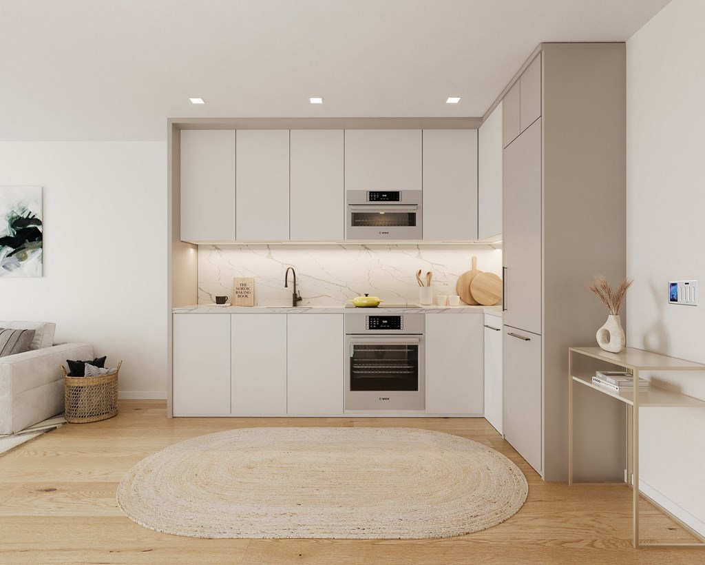 a white kitchen with white cabinets and a white rug
