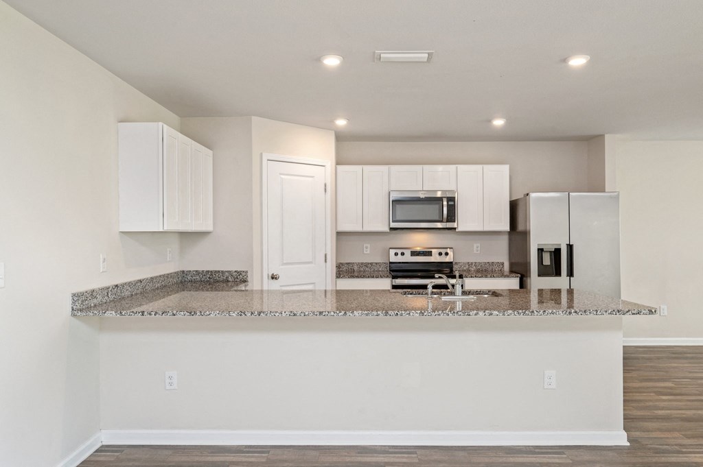 a kitchen with a granite counter top and white cabinets