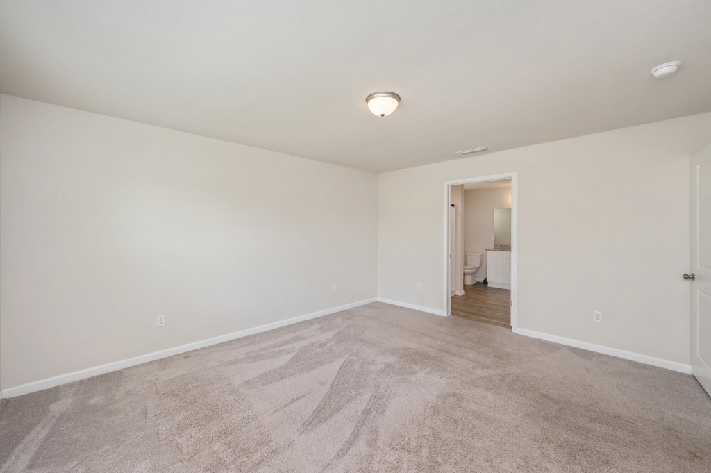 a spacious living room with carpet and white walls
