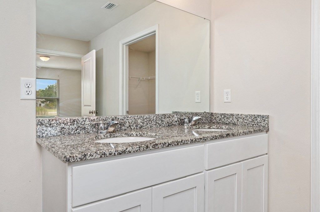 a bathroom with granite counter tops and a large mirror