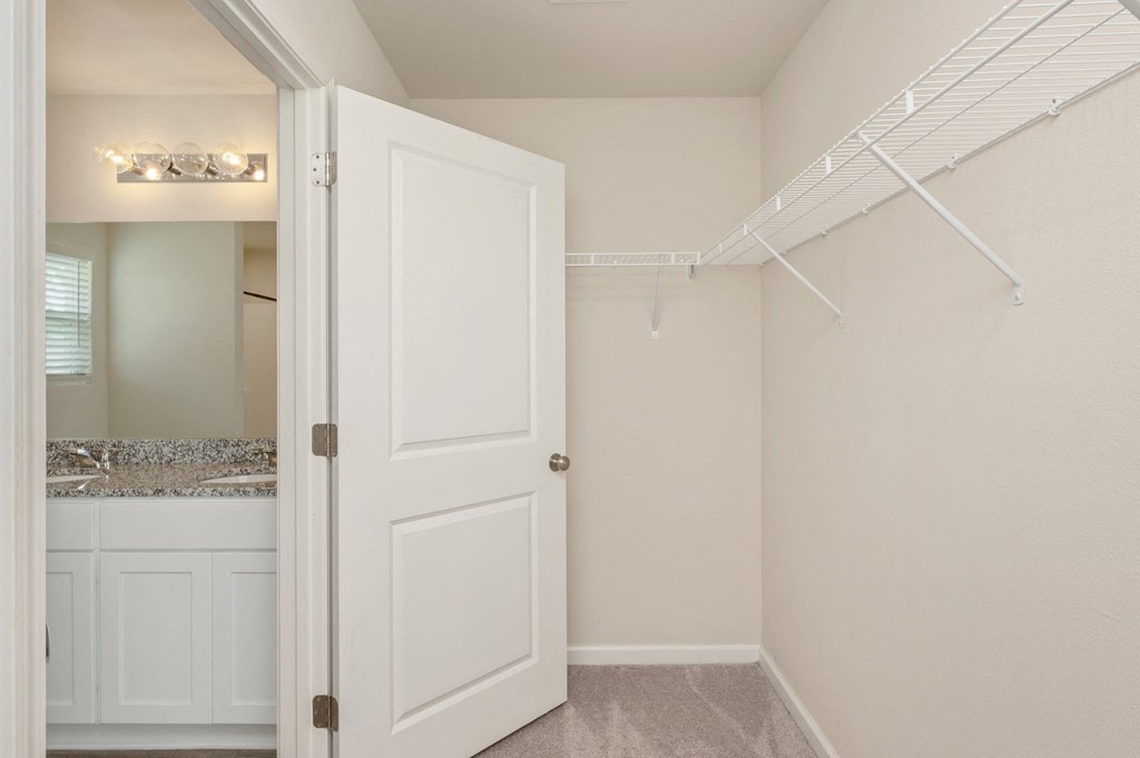 a bathroom with a closet and a sink and a white door