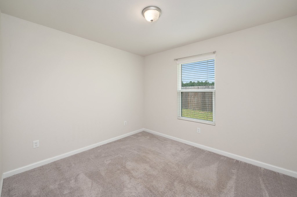 an empty room with a window and carpet