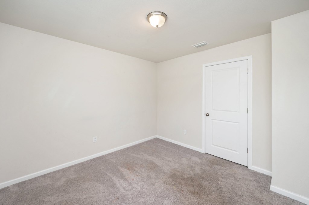 a room with a carpeted floor and a white door