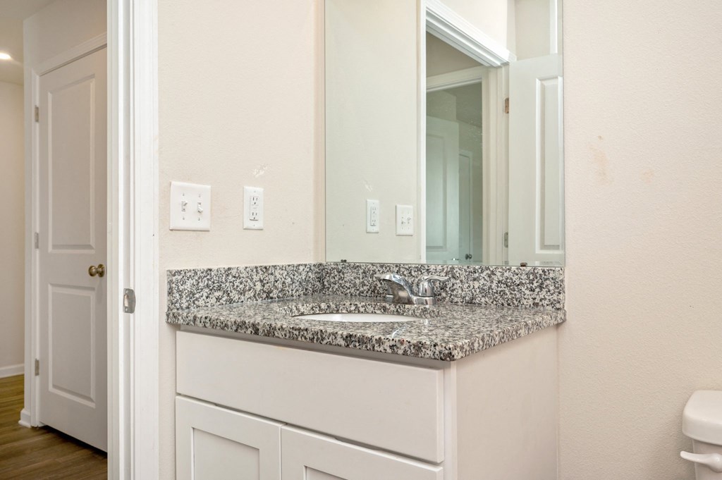 a bathroom with a granite counter top and a mirror