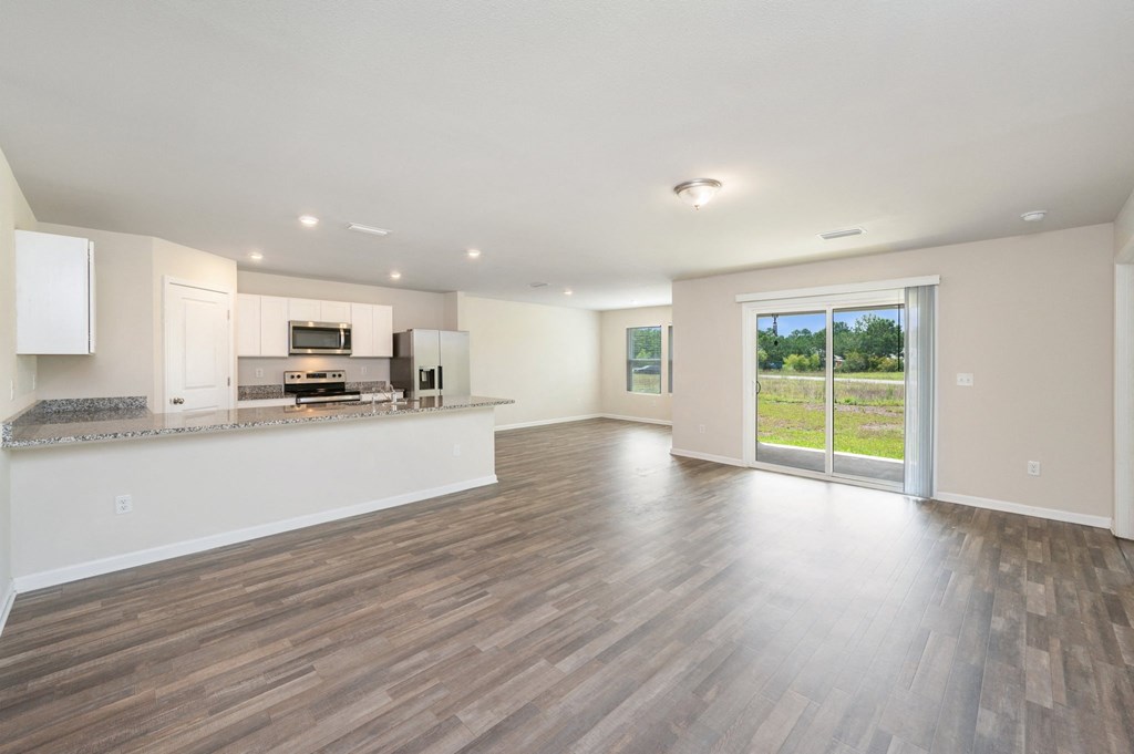 a living room with a kitchen and a sliding glass door
