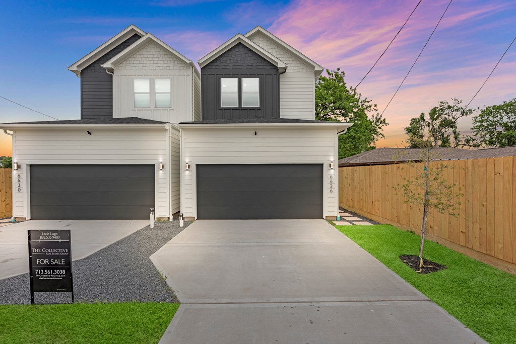 a house with two garage doors and a sidewalk in front of it