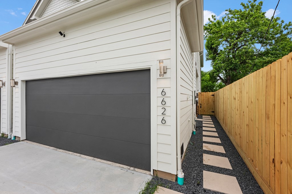 a garage with a black door on the side of a house